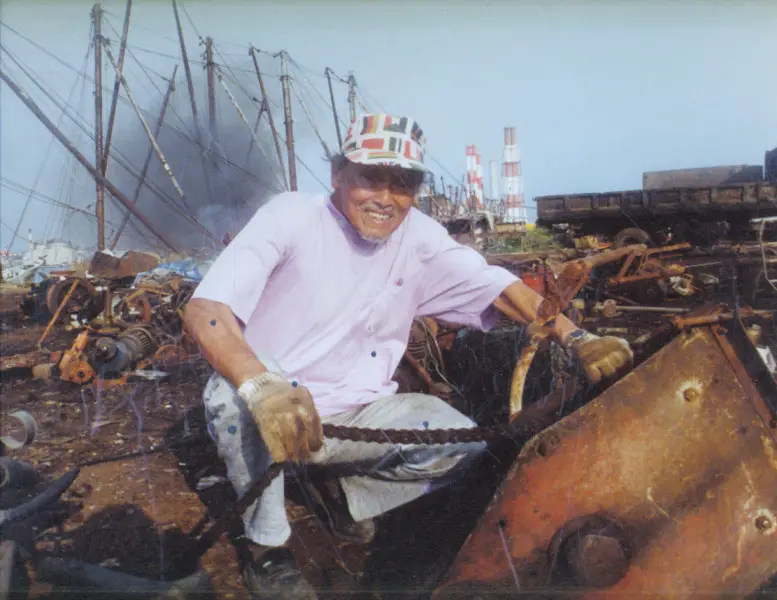 Chen Ting-shih at a scrapyard searching for materials to create a sculpture